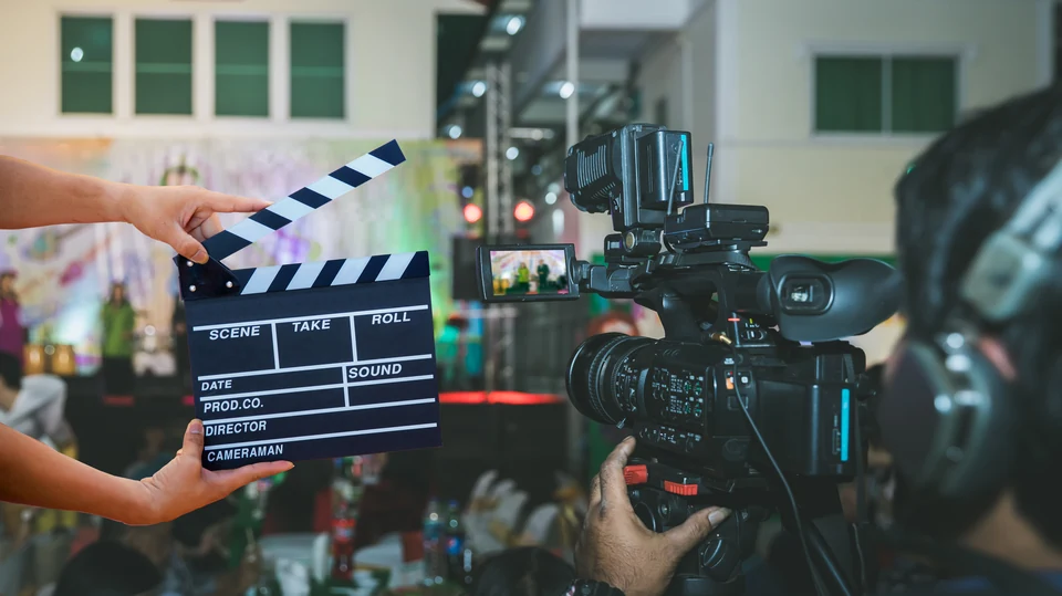 A clapperboard and a cinema camera during a film shoot.