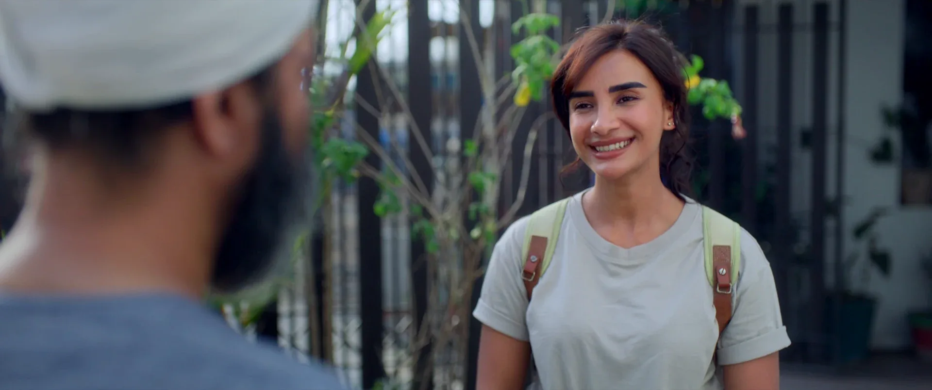 A woman smiling during an outdoor conversation in HEER SARA.