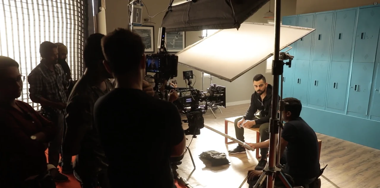 A film crew, camera and lighting setup during a brand film shoot.