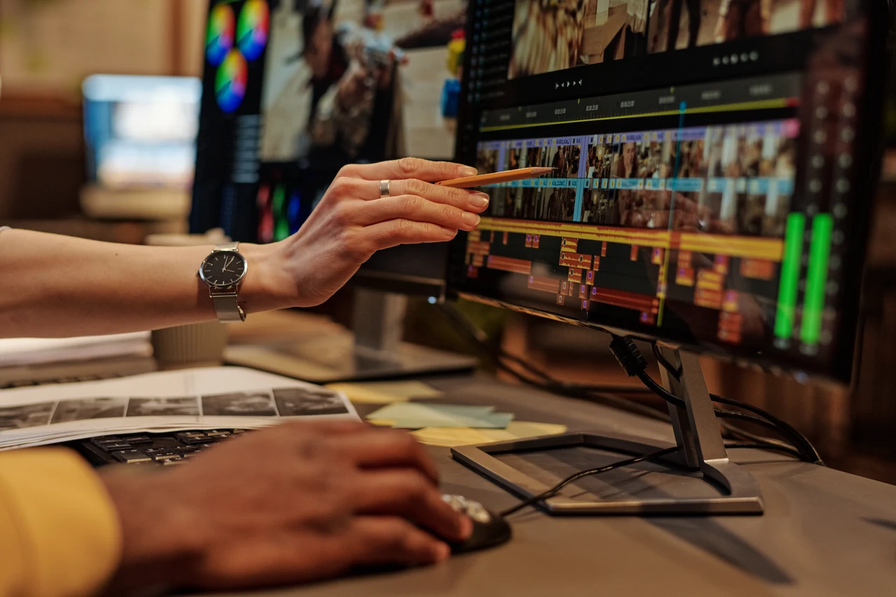 An editor working with a film timeline and preview monitors.